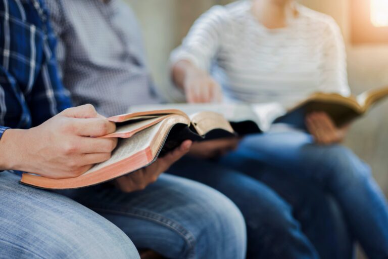 Christian friends group reading and study bible together in home or Sunday school at church with window light