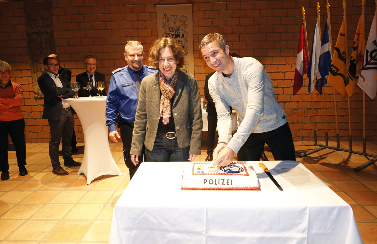 Nadja El Hamdi und Didier Mayenzet legen die neuen Gemeindewappen auf die Polizeitorte.