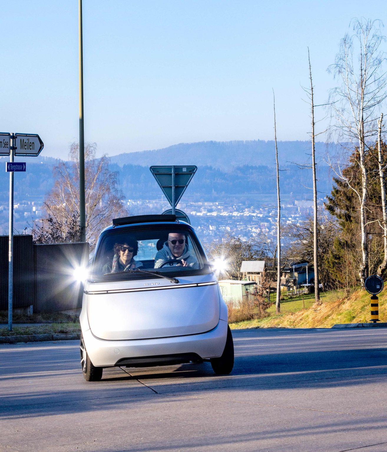 Im Microlino kommen zwei Personen herum: Thomas und Irène Ruff unterwegs auf der Meilemer Bergstrasse.
